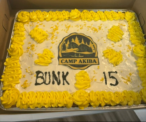 Cookie Cake with yellow and white frosting and camp logo