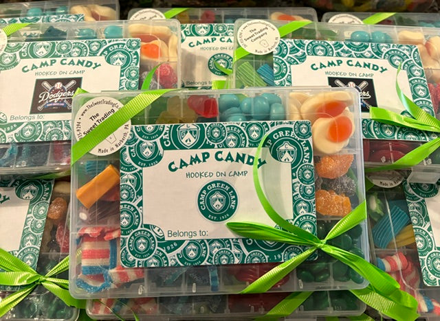 Pictured plastic boxes filled with candy and labeled with a custom camp label